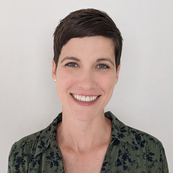 Photo of a white woman with pixie-style brown hair smiling