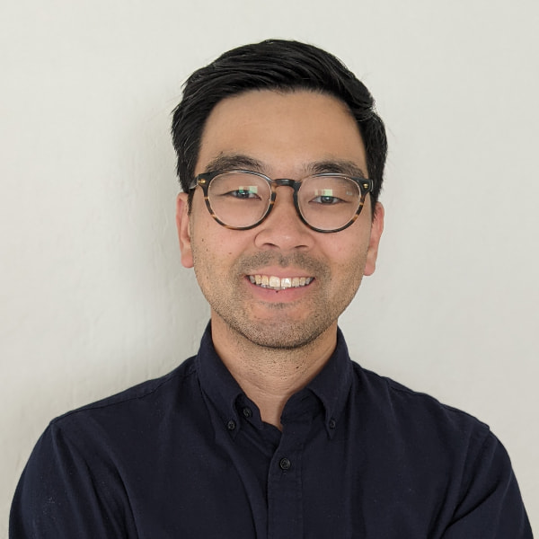 Photo of a Korean American man wearing glasses and smiling